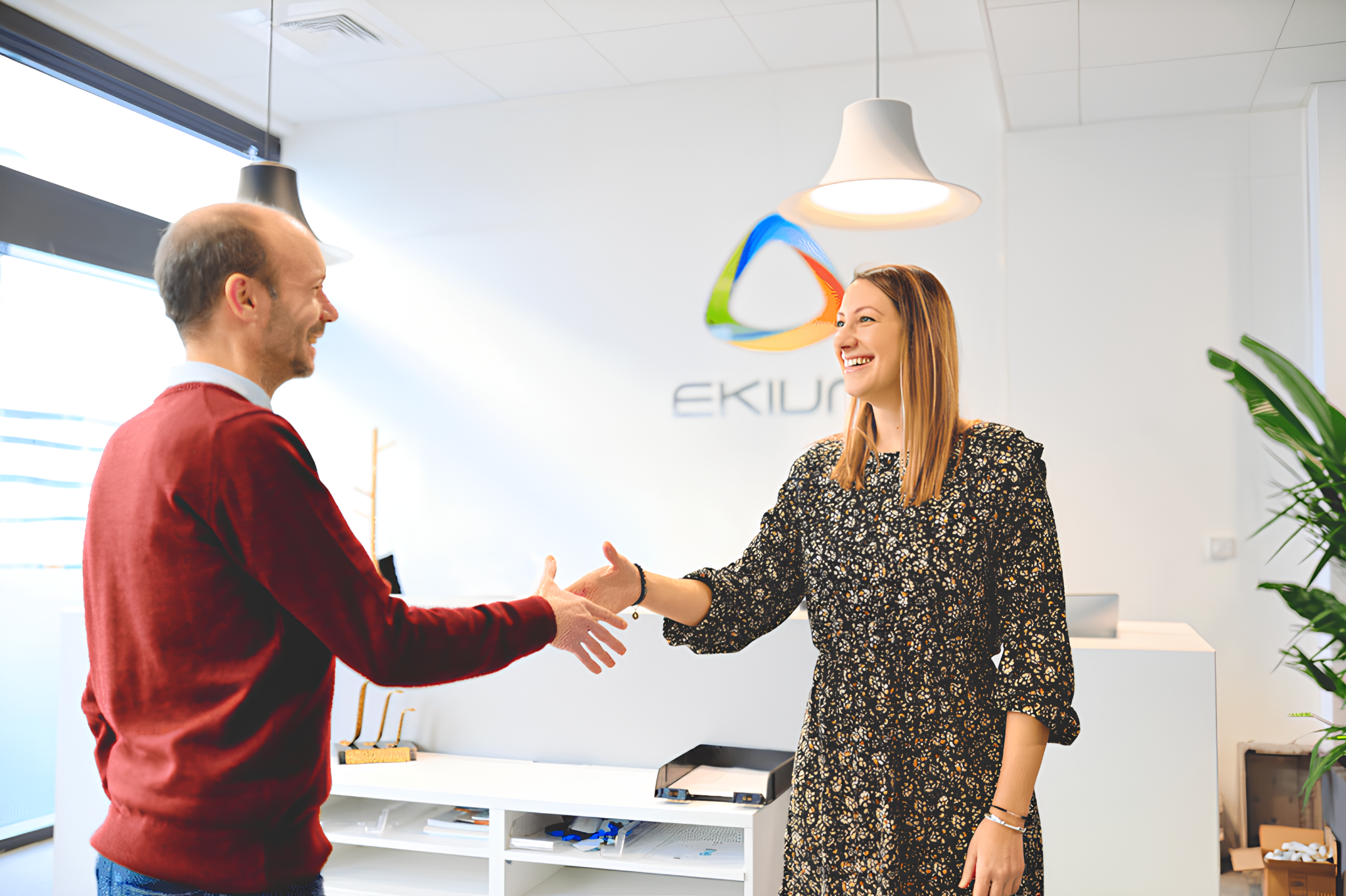 Dos profesionales saludándose en una oficina de EKIUM